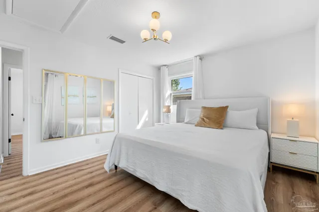 a bedroom with a bed and wooden floor