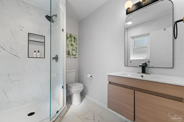 a bathroom with a sink a toilet and shower