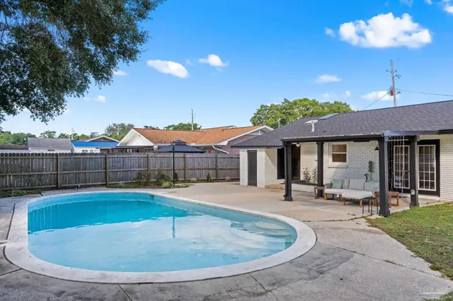 a view of a house with swimming pool and sitting area