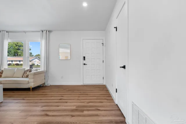a view of a livingroom with wooden floor and furniture