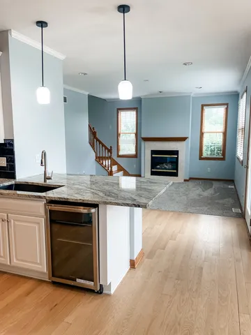 a kitchen with kitchen island granite countertop a stove a sink and a wooden floors