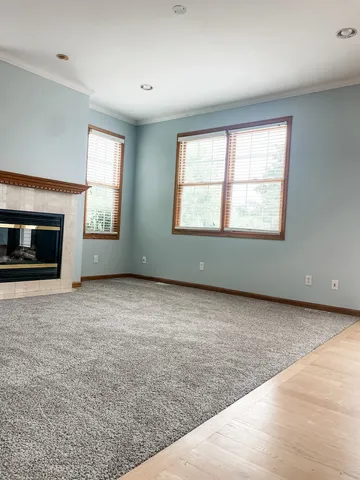 an empty room with windows and fireplace