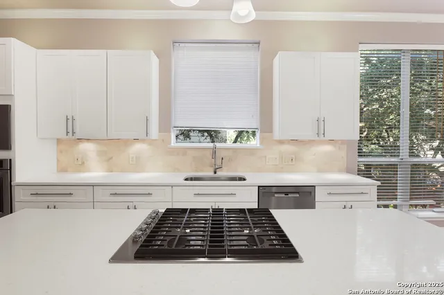 a kitchen with a white cabinets and a stove top oven