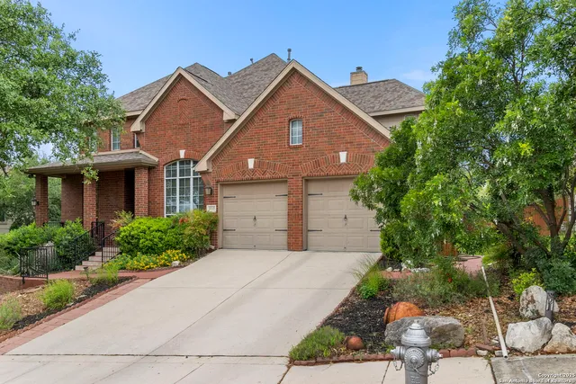 a front view of a house with a yard and potted plants