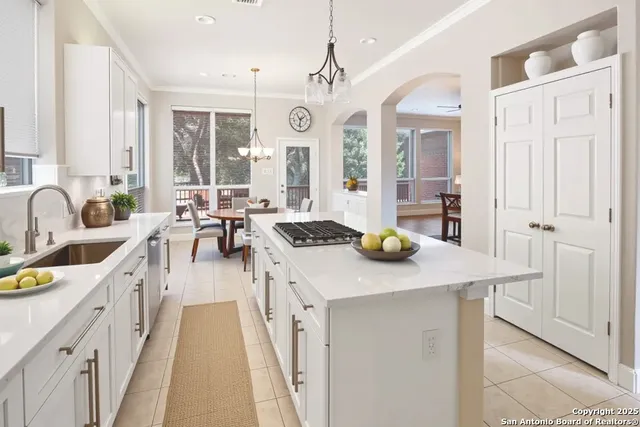 a open kitchen with a sink a stove and chairs