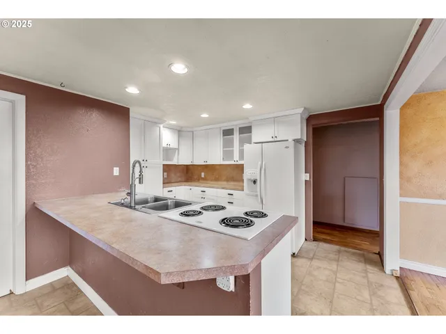 a kitchen with stainless steel appliances granite countertop a sink refrigerator and cabinets