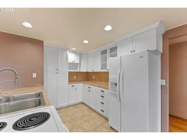 a kitchen with a refrigerator sink and cabinets