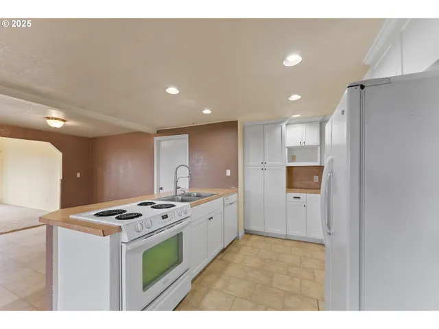 a kitchen with stainless steel appliances kitchen island a sink a stove and refrigerator