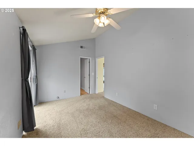 a view of a big room with chandelier fan