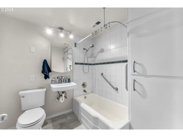 a bathroom with a toilet sink a mirror and bathtub