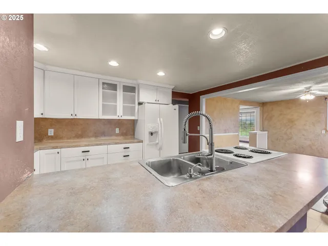 a kitchen with stainless steel appliances granite countertop a sink refrigerator and cabinets