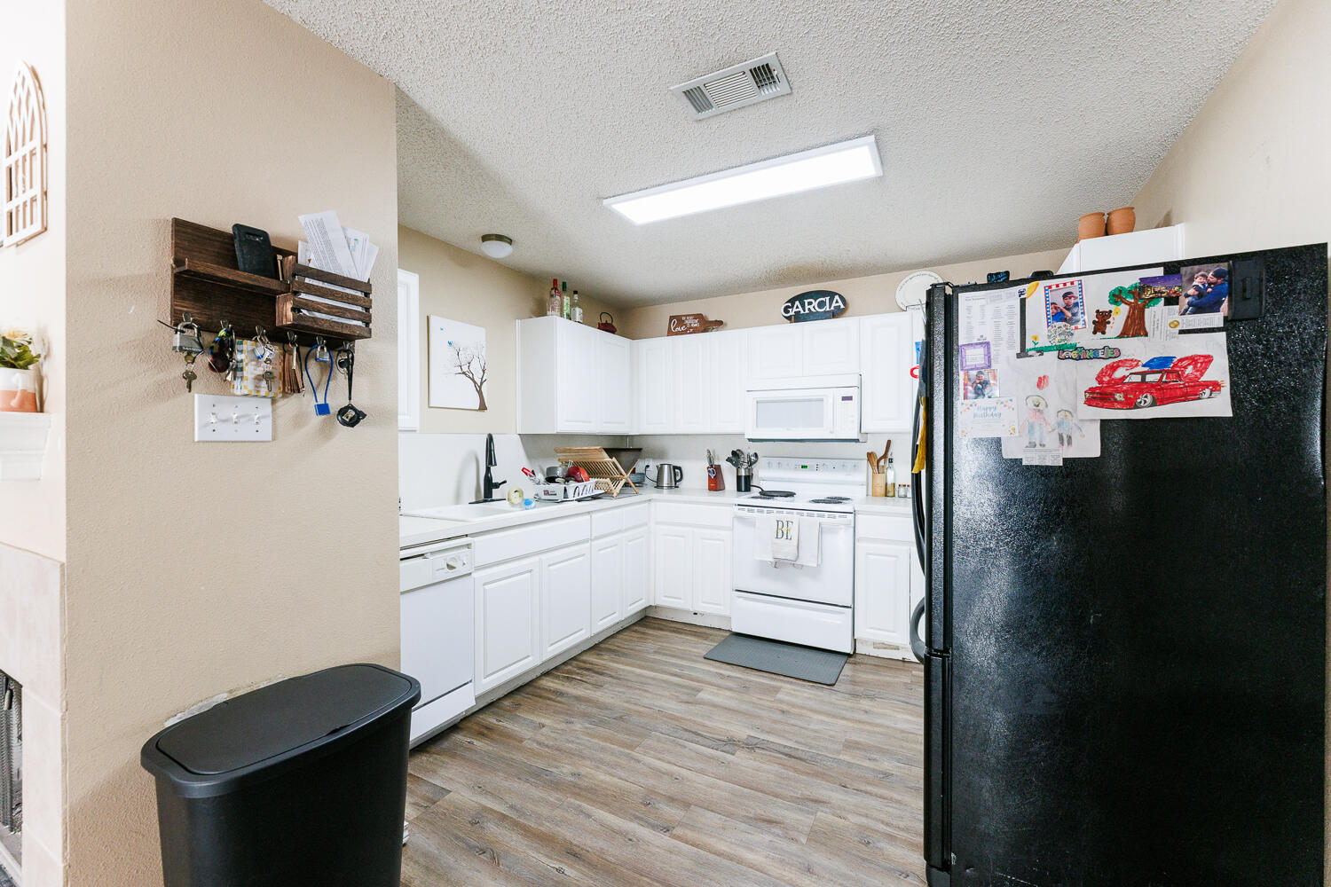 3423 97th Street Lubbock, TX 79423 - Photo 13 of 26 a kitchen with a refrigerator and white cabinets