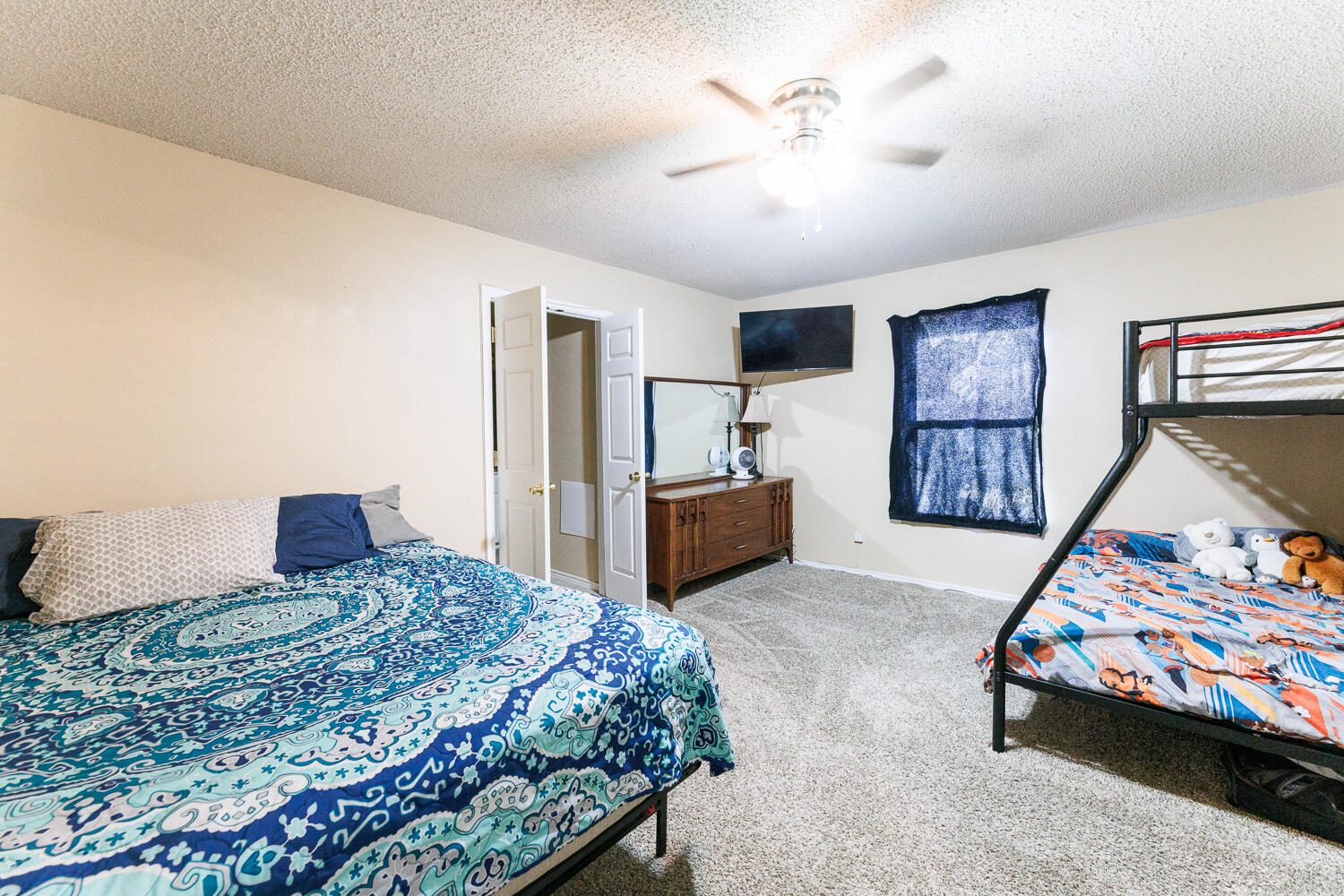 3423 97th Street Lubbock, TX 79423 - Photo 17 of 26 a bedroom with a bed and a tv on the dresser