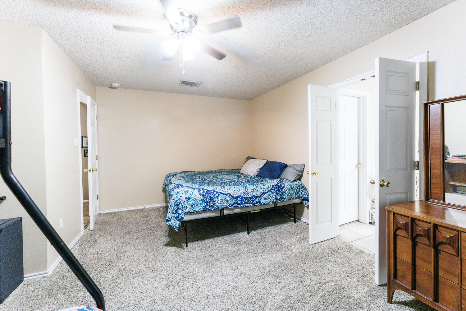 3423 97th Street Lubbock, TX 79423 - Photo 18 of 26 a bedroom with a bed and a dresser with wooden floor
