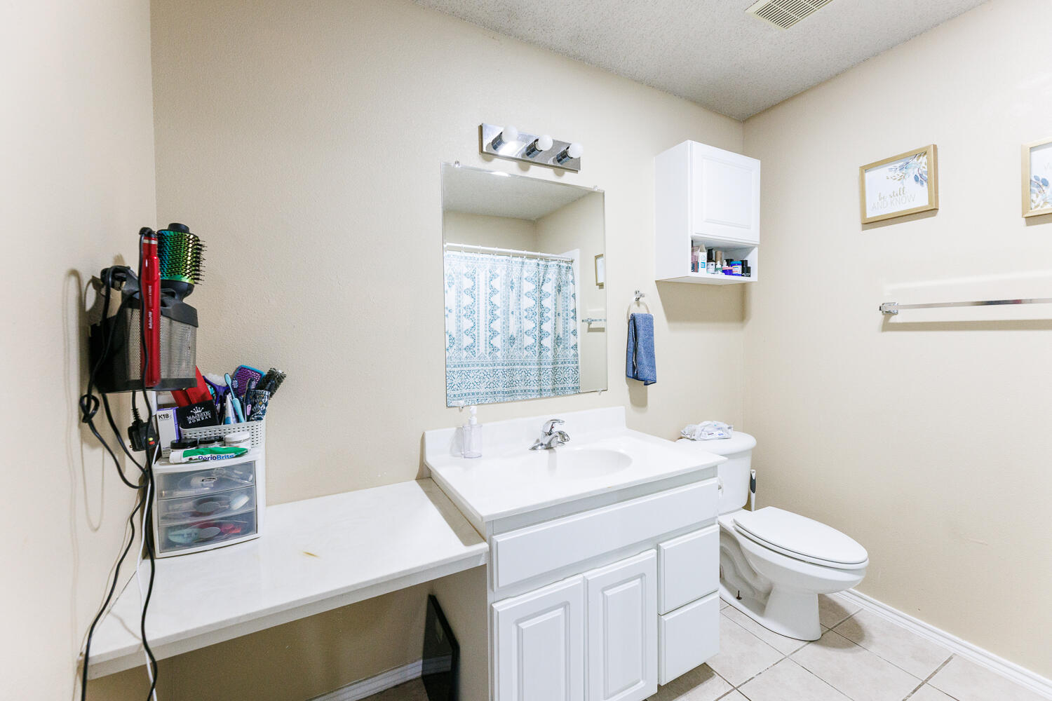 3423 97th Street Lubbock, TX 79423 - Photo 19 of 26 a bathroom with a sink mirror and toilet