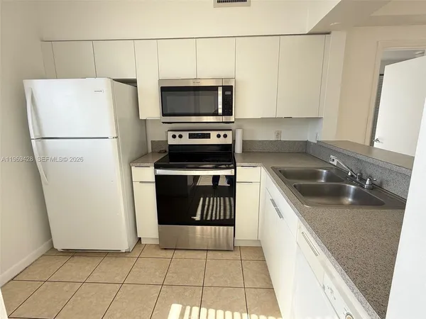 a kitchen with a sink a refrigerator and a stove top oven