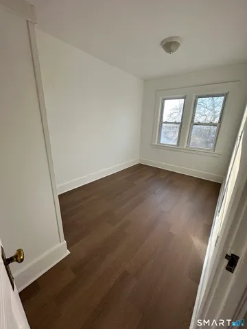 a view of a livingroom with wooden floor and window