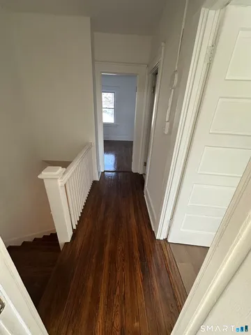 a view of a hallway view with wooden floor and staircase