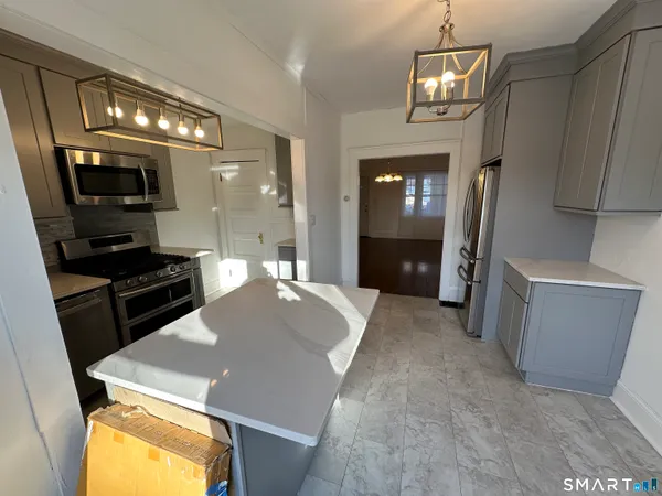 a large kitchen with a sink a refrigerator and a stove top oven