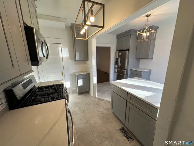 a kitchen with a refrigerator and a stove top oven