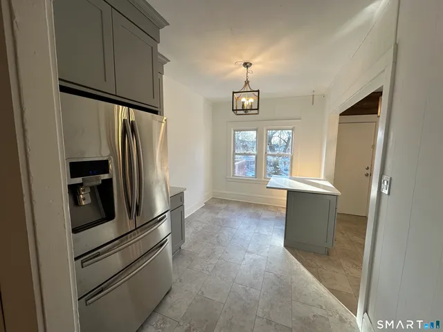 a kitchen with stainless steel appliances a refrigerator and a window