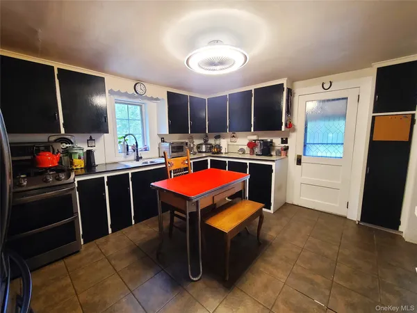 a room with furniture a flat screen tv and kitchen view