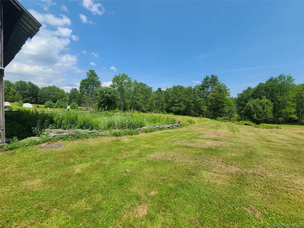 a view of a green field with wooden fence