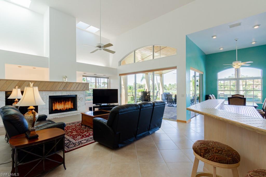 4401 Pond Apple Drive South Naples, FL 34119 - Photo 11 of 35 a living room with furniture a flat screen tv and a fireplace