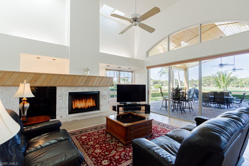 4401 Pond Apple Drive South Naples, FL 34119 - Photo 12 of 35 a living room with furniture a flat screen tv and a fireplace