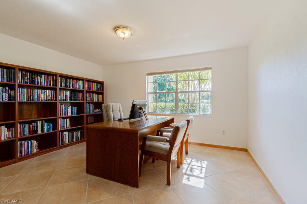 4401 Pond Apple Drive South Naples, FL 34119 - Photo 23 of 35 a view of a workspace with furniture and a bookshelf