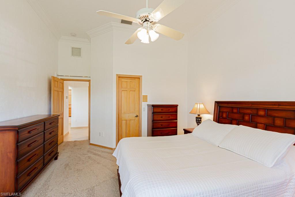 4401 Pond Apple Drive South Naples, FL 34119 - Photo 27 of 35 a bedroom with a bed and a chandelier