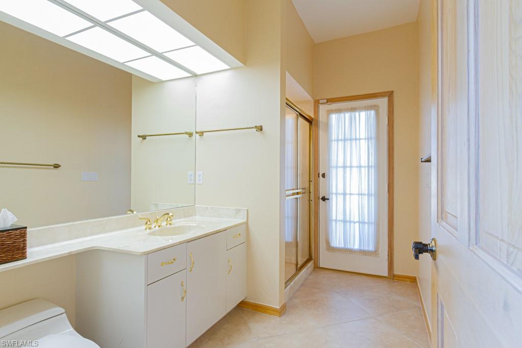 4401 Pond Apple Drive South Naples, FL 34119 - Photo 28 of 35 a bathroom with a double vanity sink a mirror and a bathtub