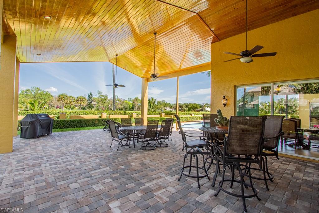 4401 Pond Apple Drive South Naples, FL 34119 - Photo 29 of 35 a view of a patio with a table chairs and a backyard