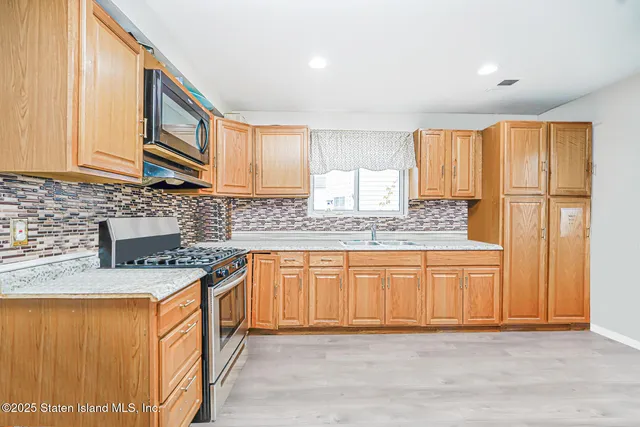 a kitchen with stainless steel appliances granite countertop a sink stove and cabinets