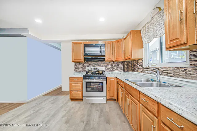 a kitchen with stainless steel appliances granite countertop a sink a stove top oven and granite counter tops