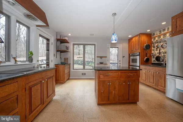 a large kitchen with stainless steel appliances kitchen island granite countertop a large stove a sink dishwasher and a oven with granite countertops