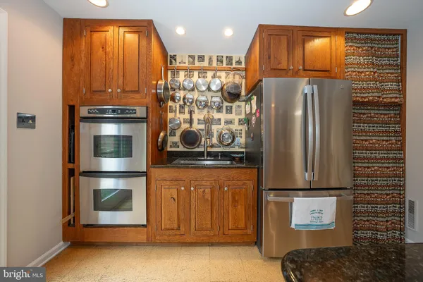 a kitchen with stainless steel appliances granite countertop a refrigerator and a stove