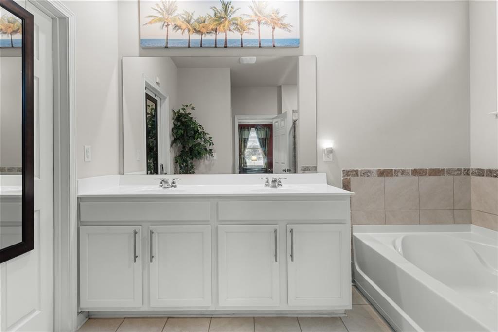 1476 Harlequin Way Stockbridge, GA 30281 - Photo 24 of 57 a bathroom with a double vanity sink a mirror and bathtub
