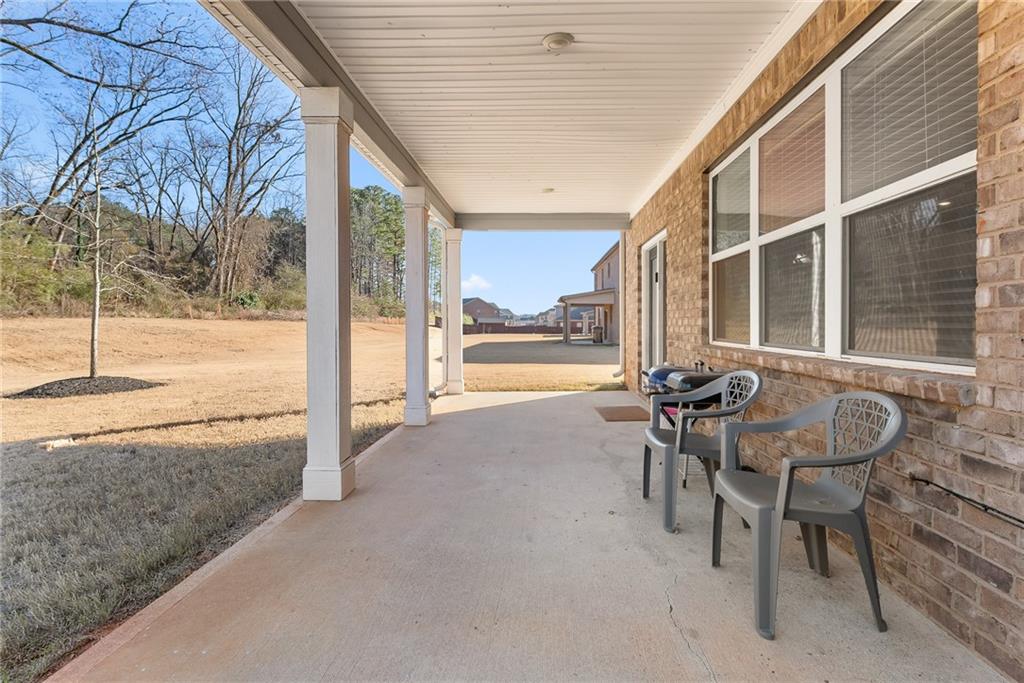 1476 Harlequin Way Stockbridge, GA 30281 - Photo 51 of 62 a view of a patio with table and chairs and floor to ceiling window