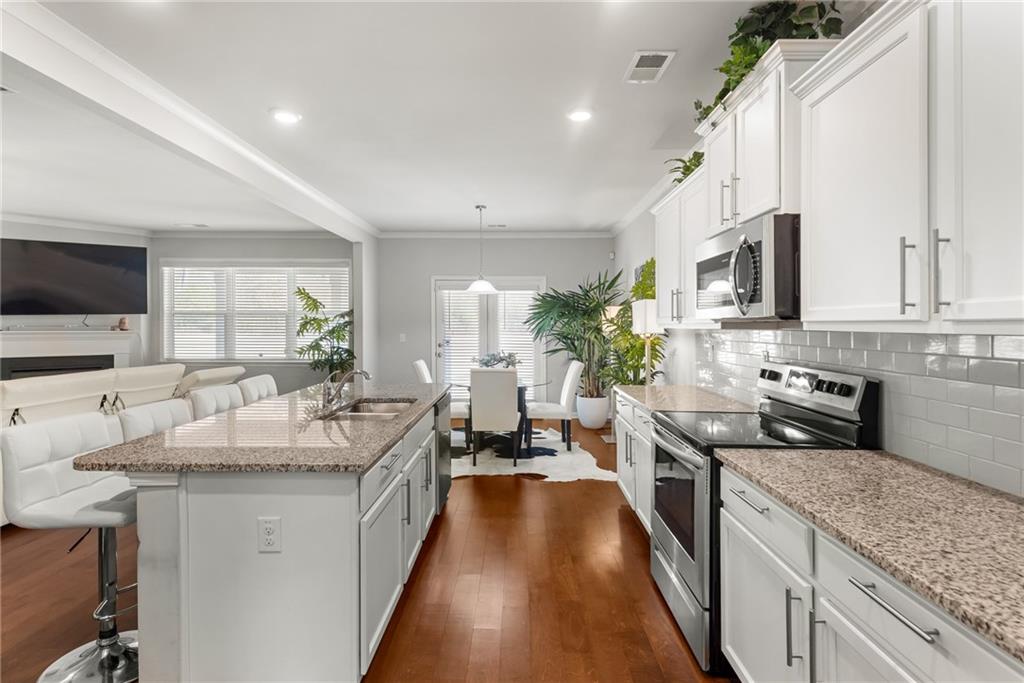 1476 Harlequin Way Stockbridge, GA 30281 - Photo 7 of 57 a kitchen with granite countertop a sink stove and cabinets