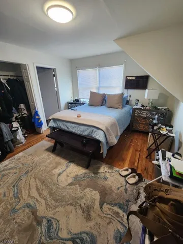 a bedroom with a bed and a view of living room