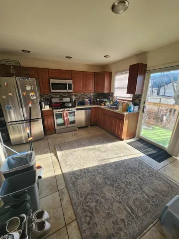 a large kitchen with stainless steel appliances kitchen island granite countertop a sink and cabinets