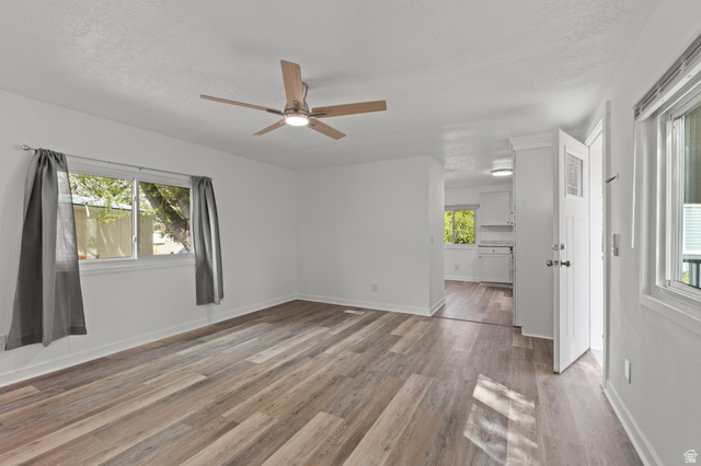 350 West 800 South, Unit 2 Logan, UT 84321 - Photo 3 of 22 Spare room with plenty of natural light, dark wood finished floors, a ceiling fan, and a textured ceiling