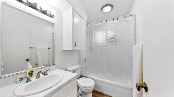 a bathroom with a sink a toilet and shower