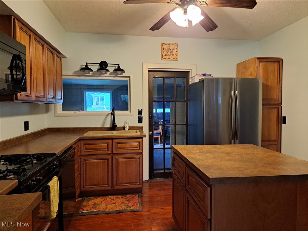 49197 John Tomcho Road Cumberland, OH 43732 - Photo 20 of 50 Kitchen with black appliance, dark hardwood / wood-style flooring, sink, and ceiling fan