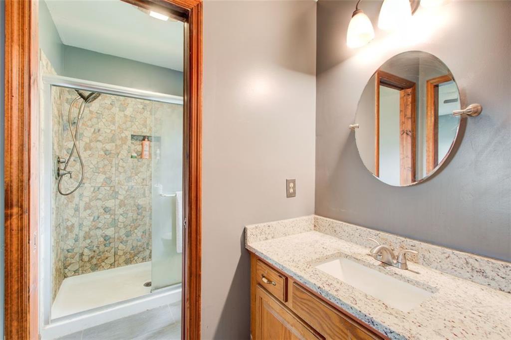 8345 Cleckler Road Palmetto, GA 30268 - Photo 37 of 41 a bathroom with a granite countertop sink a mirror and a shower