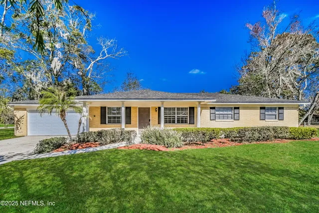 a front view of a house with a garden