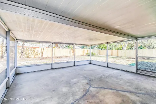 a view of an empty room with a large window with outdoor view