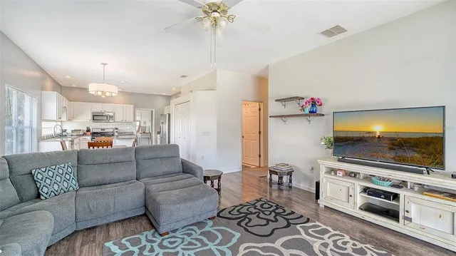 a kitchen with a table chairs a sink dishwasher refrigerator and cabinets
