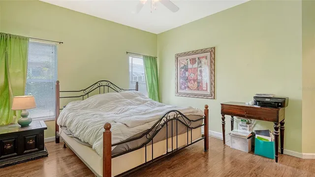 a bedroom with a large bed and a painting on the wall